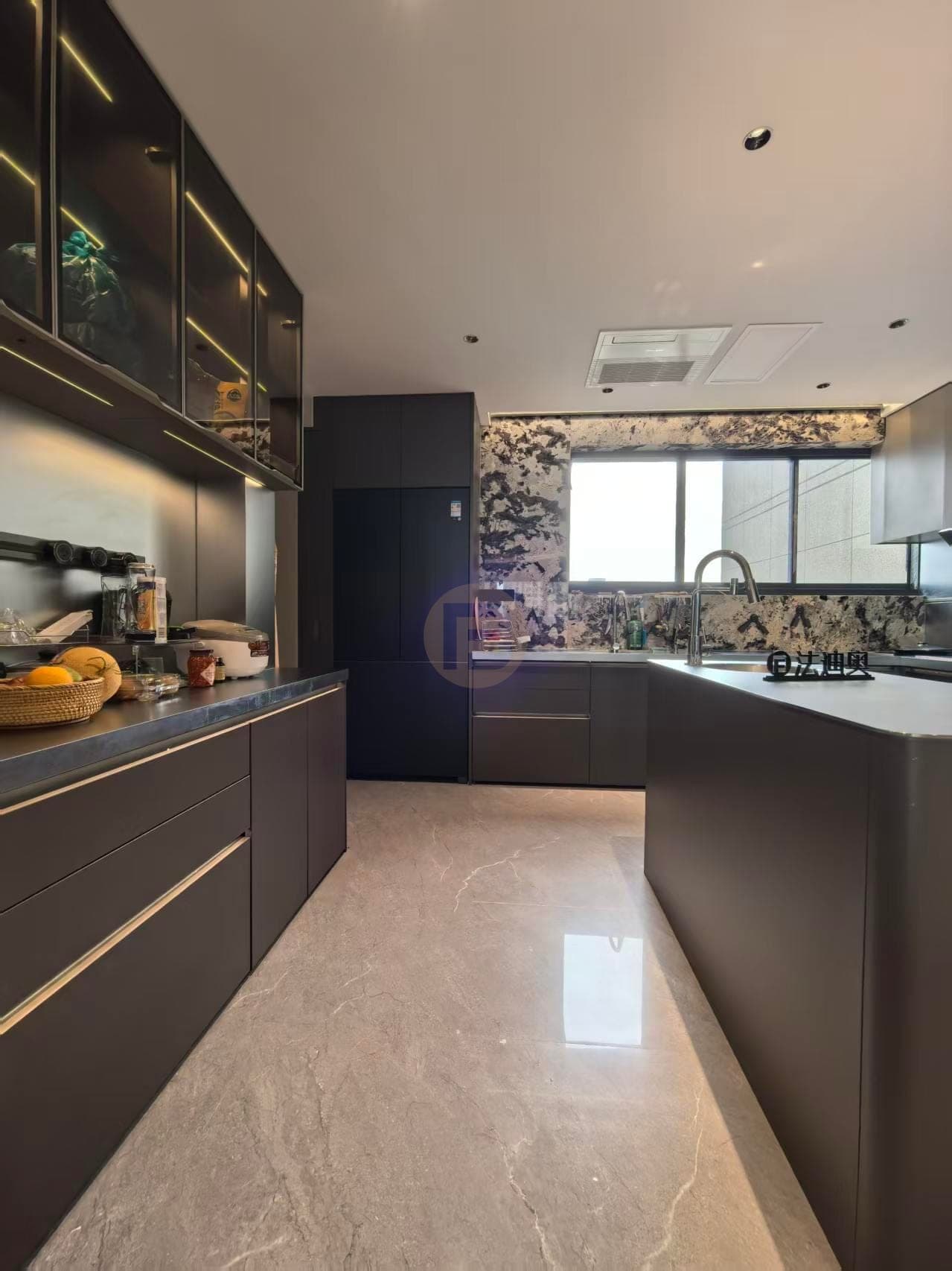 Dark kitchen cabinet wall with glass upper cabinets, linear lighting and a counter